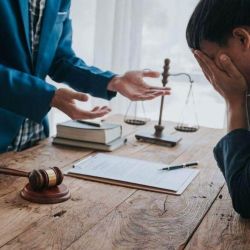 Two people discussing wrongful death lawsuit damages at a table