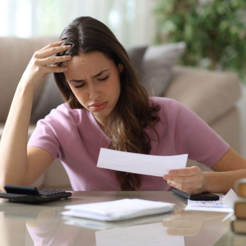 Woman reviewing insurance claim documents with a calculator