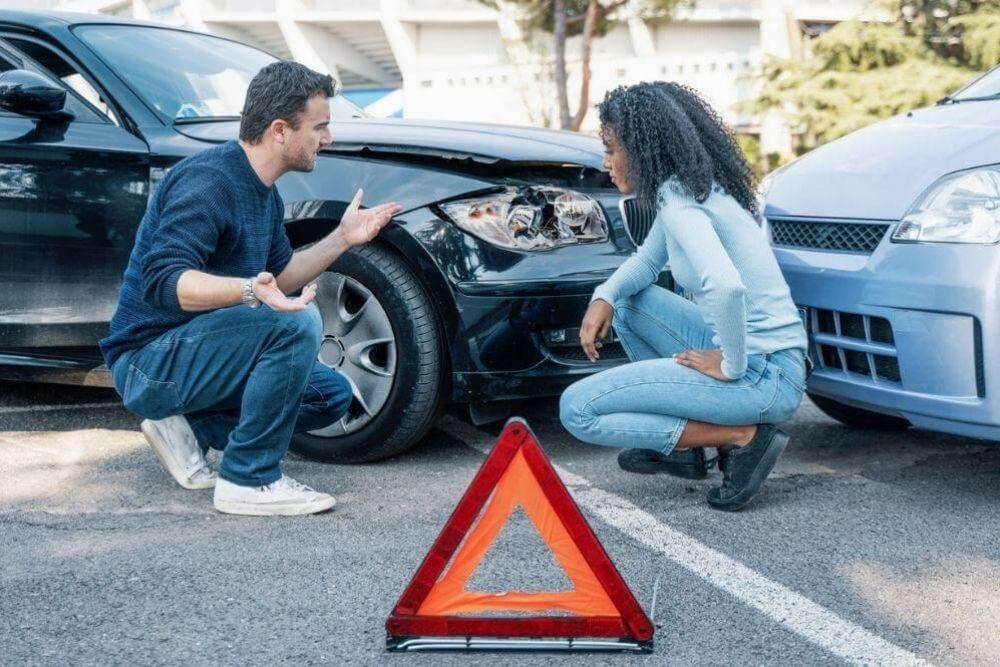Man kneeling next to woman at the scene of
