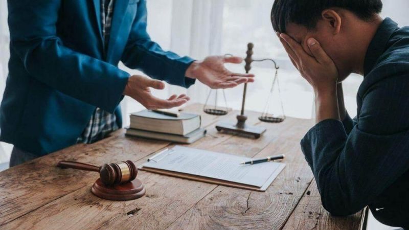 Two people discussing wrongful death lawsuit damages at a table