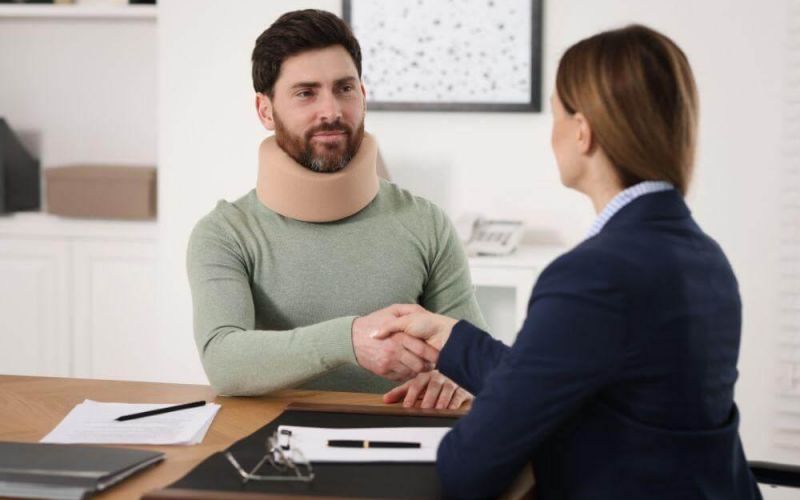 Woman shaking hands with her car accident lawyer in