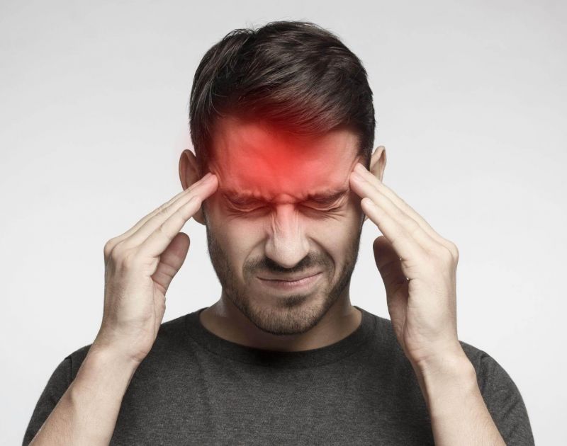 a man holding his head with both hands