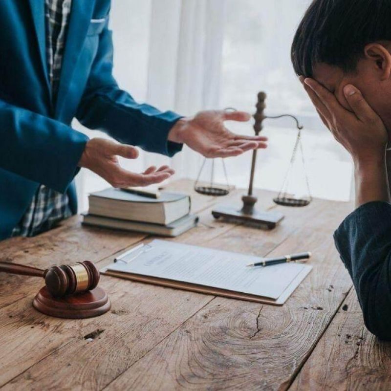 Two people discussing wrongful death lawsuit damages at a table