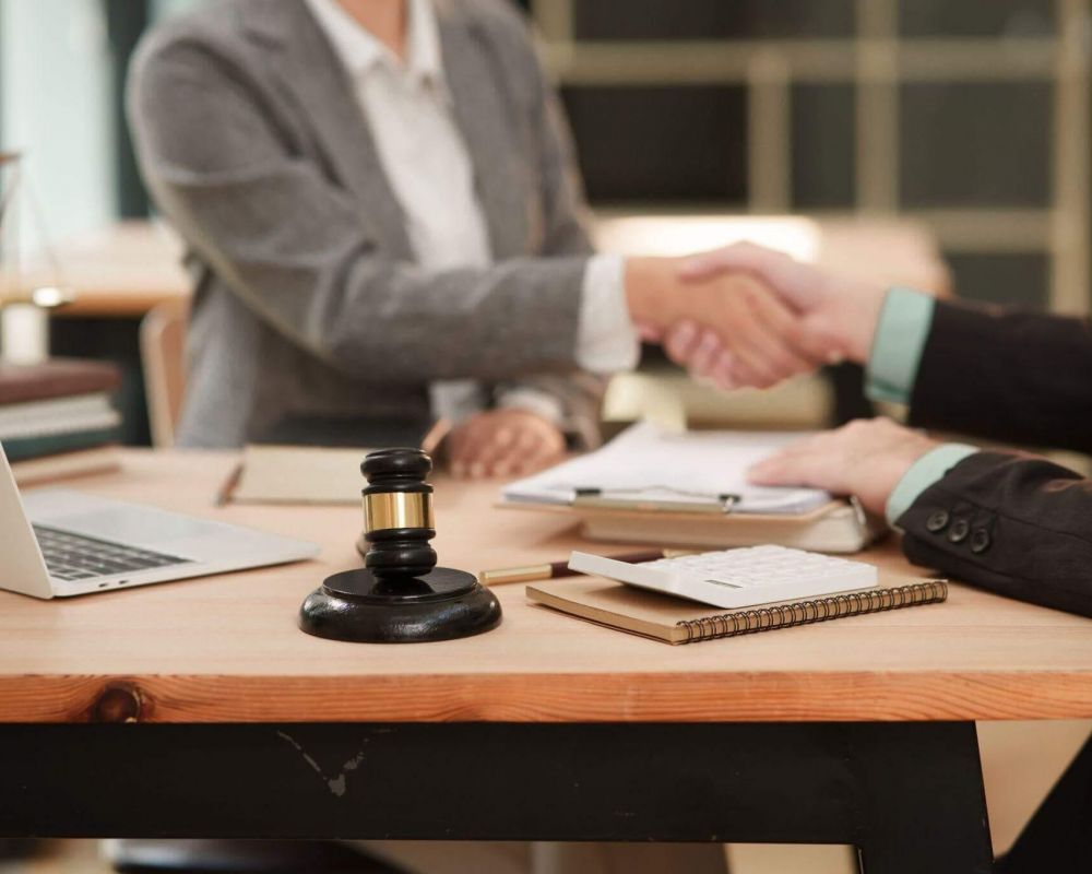 two people shaking hands over a wooden table