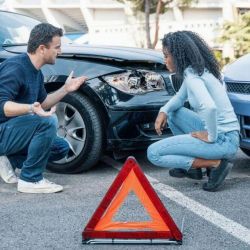 Man kneeling next to woman at the scene of