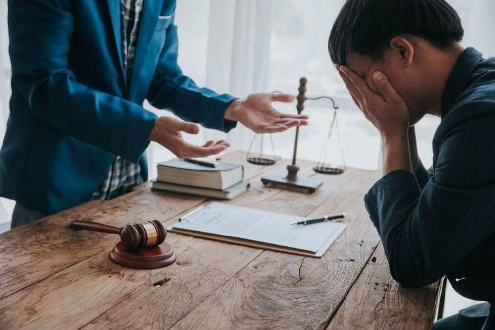 Two people discussing wrongful death lawsuit damages at a table
