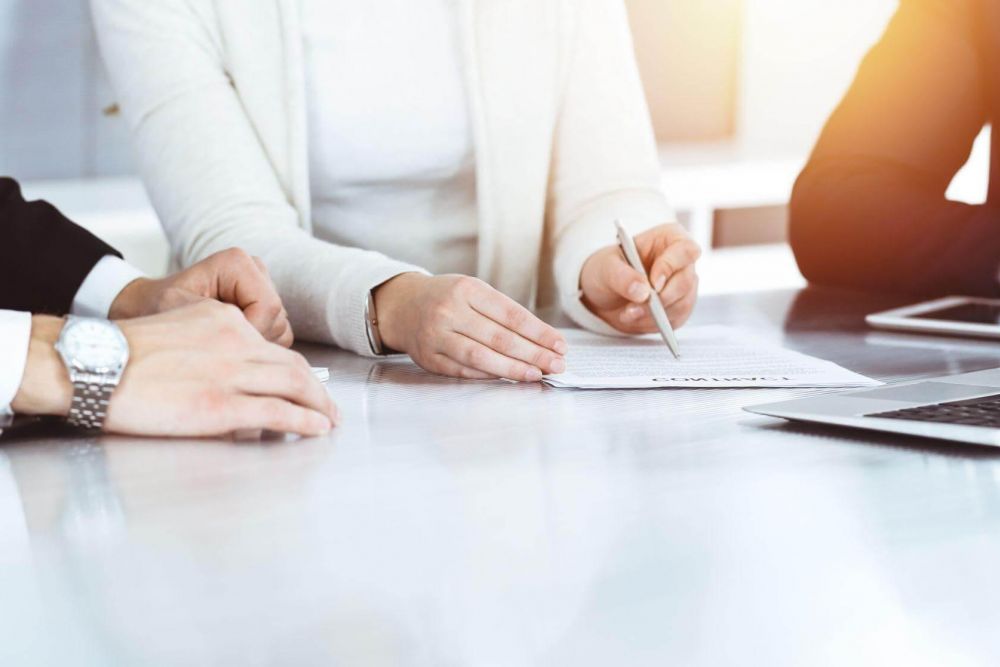 a group of people sitting at a table with a laptop