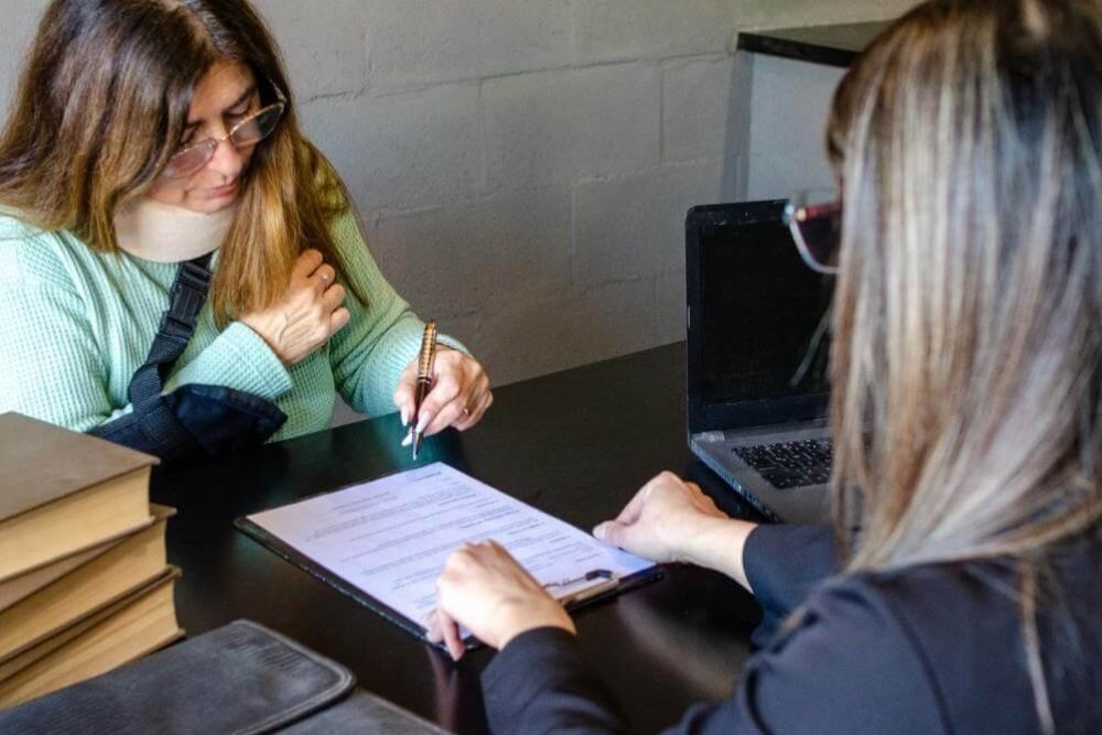 Two women reviewing documents related to a personal injury lawsuit