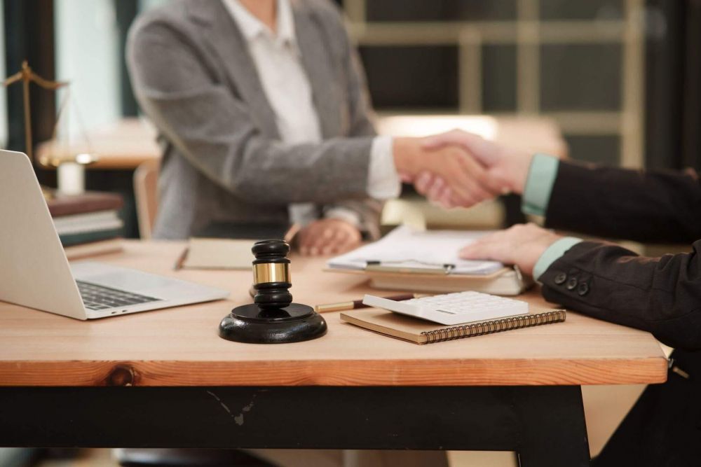 two people shaking hands over a wooden table