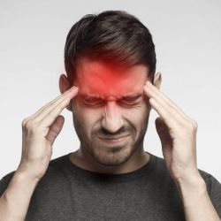 a man holding his head with both hands