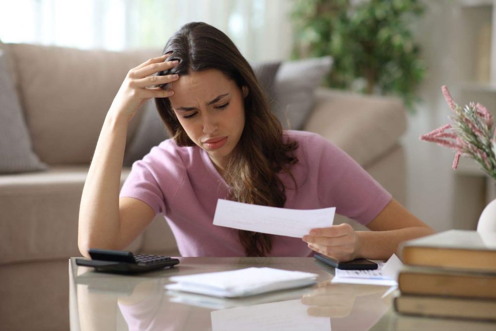 Woman reviewing insurance claim documents with a calculator