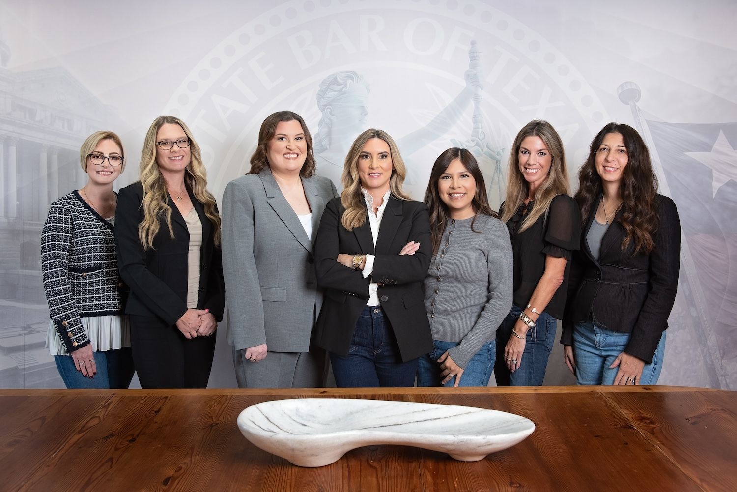 Jennifer LeMaster, Abbie Berger, and the LeMaster Law Firm team standing together in front of a State Bar of Texas wall graphic.