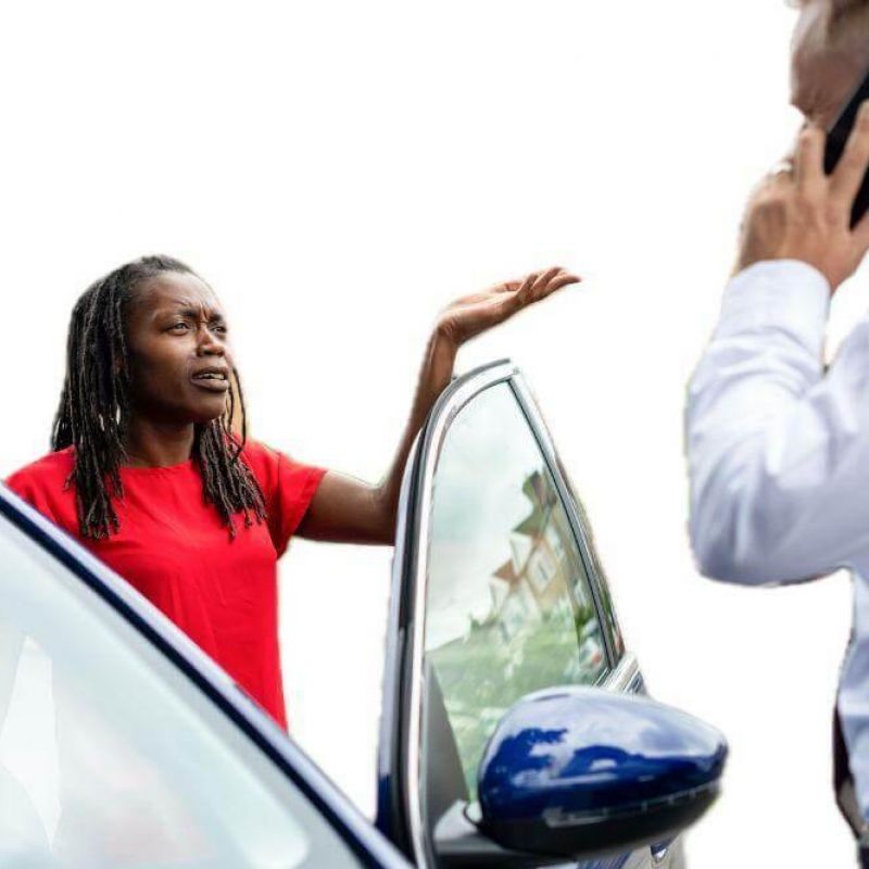 a woman talking on a cell phone next to a car