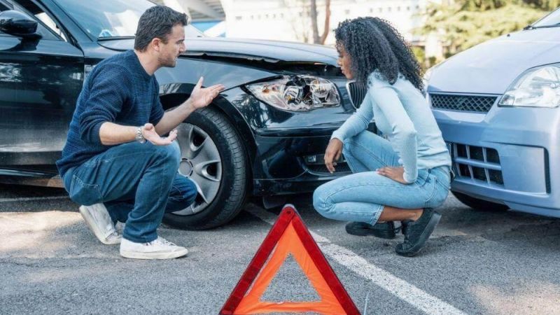 Man kneeling next to woman at the scene of