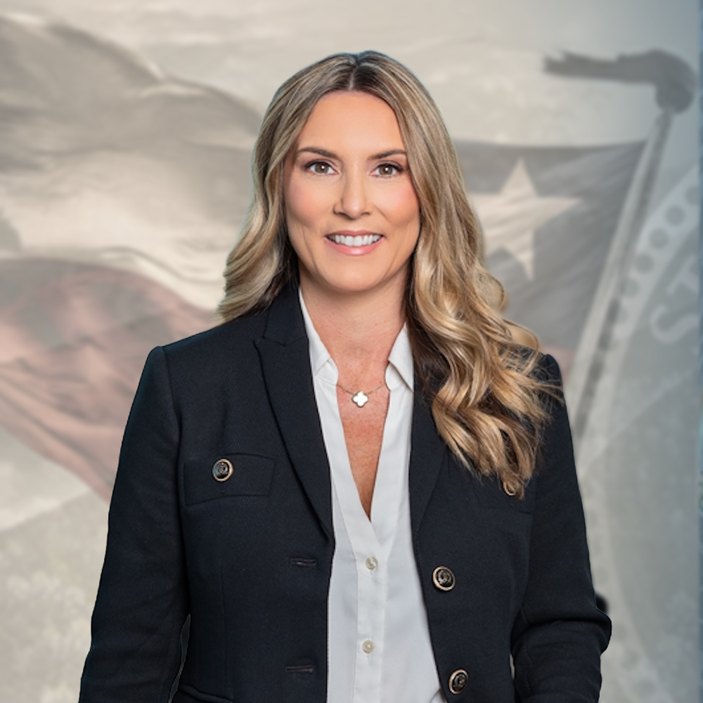 Smiling professional woman in blazer with flag backdrop, representing leadership and confidence.