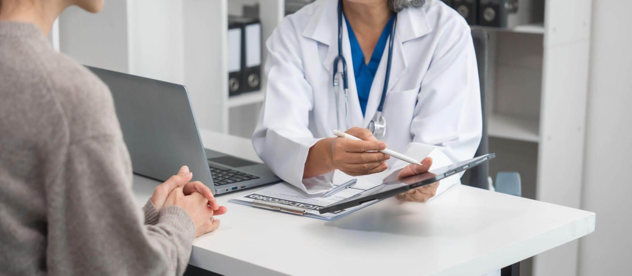 a doctor and a patient sitting at a desk