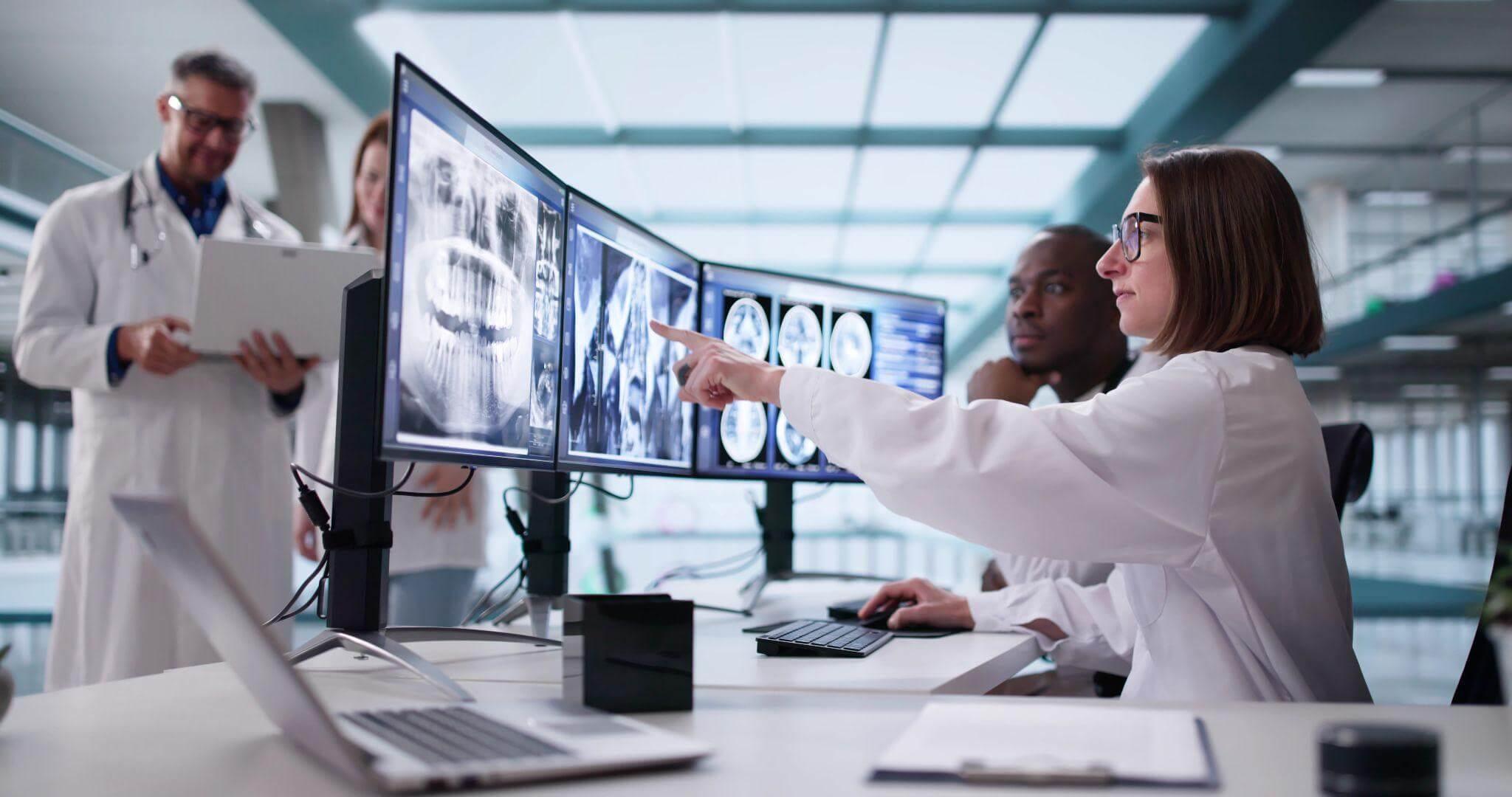 a group of doctors looking at a computer screen