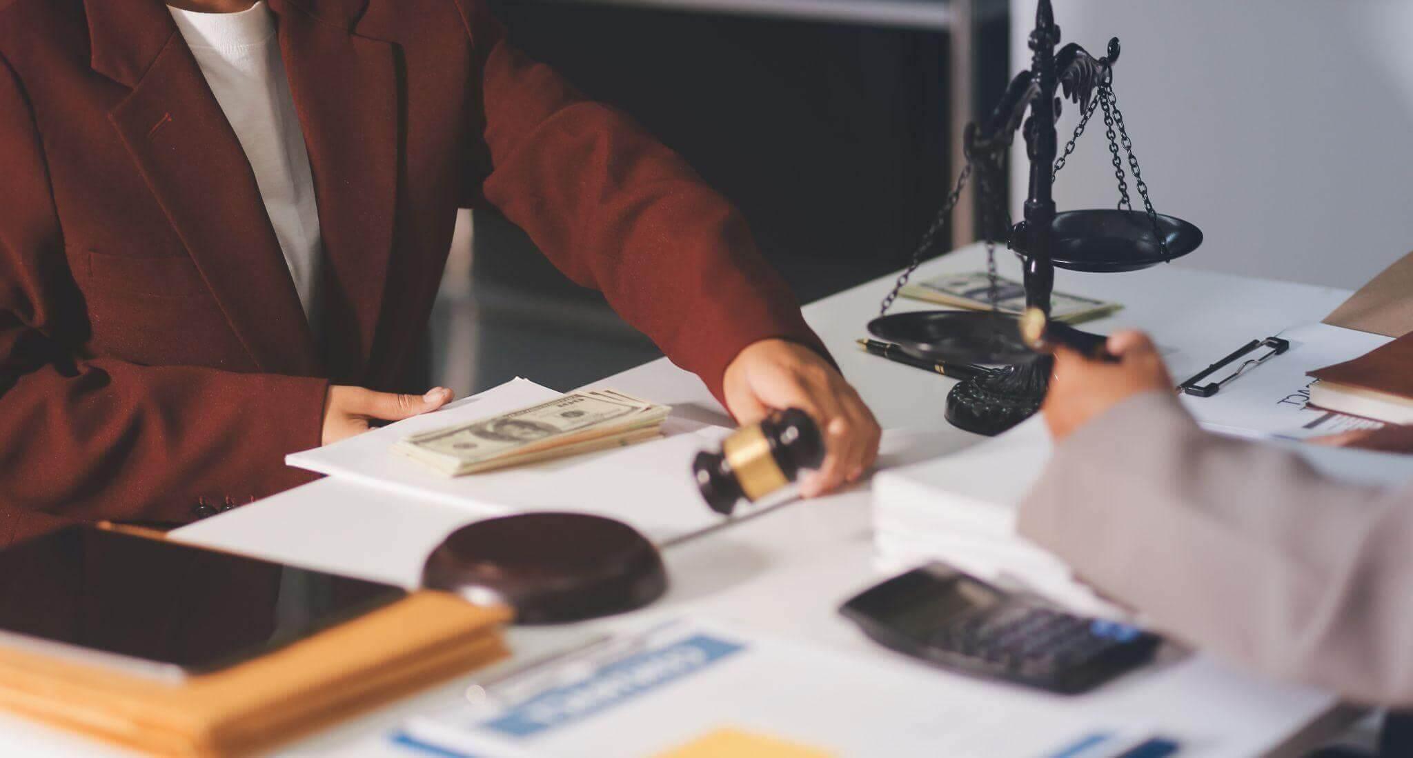 two people sitting at a desk with papers and a calculator