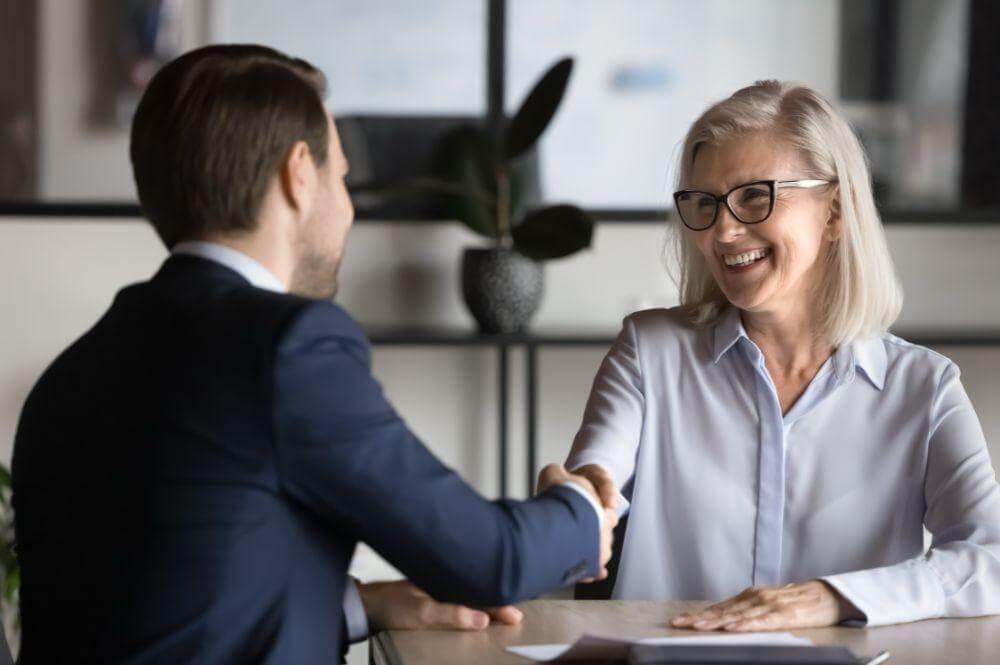a woman shaking hands with a man in a suit
