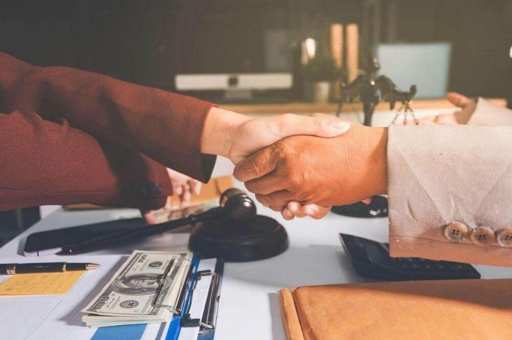 Two people shaking hands over a table