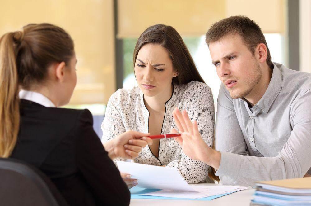 Two people discuss insurance claim denials at