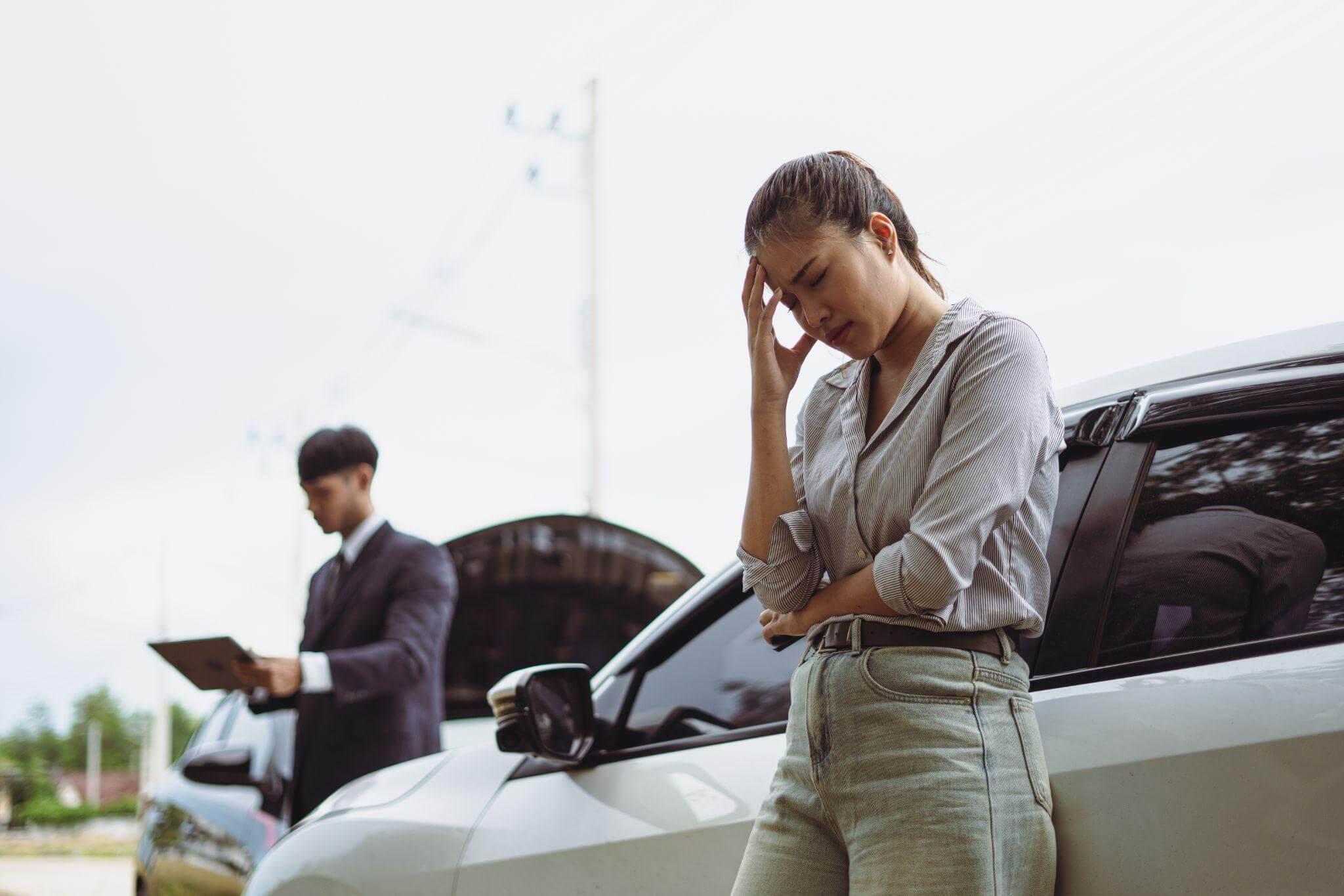 Woman in distress next to a car,