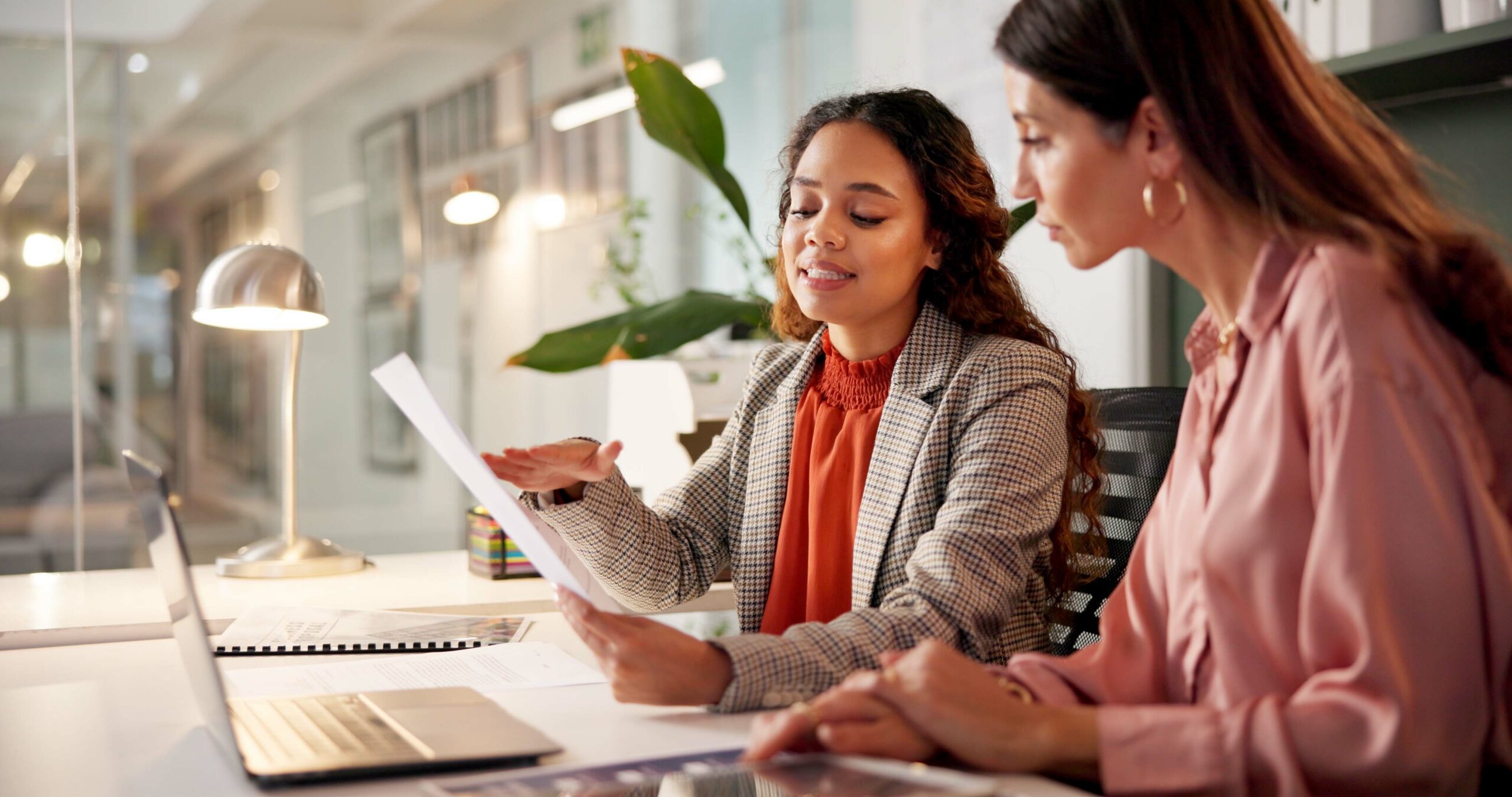 Planning reading and financial advisor with client for document investment discussion and tips Business office women team and talking with paperwork for policy review laptop or corporate meeting | LeMaster Law Firm Legal professional reviewing documents with a client during the Texas personal injury lawsuit process.